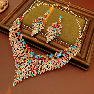 Close-up of vintage gold necklace and teardrop earrings with multi-color rhinestones
