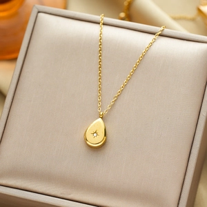 Elegant gold titanium steel teardrop necklace with sparkling starburst zircon on a gift box