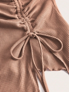 Detail of taupe waffle knit crop top featuring ribbed texture and adjustable drawstring bow