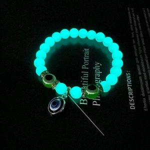 Luminous beads on Turkish Evil Eye bracelet glowing in dark macro detail
