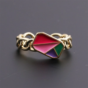 Detailed macro view of gold-plated ring featuring colorful enamel blocks and chain texture