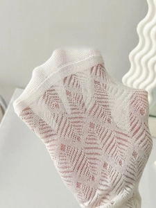 Detailed macro view of cream lace mesh socks featuring delicate leaf-shaped textures