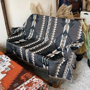 Detail of bohemian cotton camping blanket with ethnic geometric patterns and fringe edges