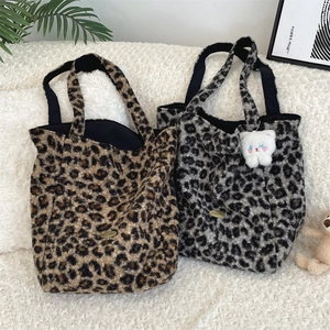 Close-up of fluffy leopard print tote bags in brown and grey with soft plush texture