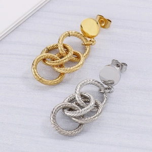 Détail de boucles d'oreilles aux anneaux torsadés entrelacés en finitions or et argent