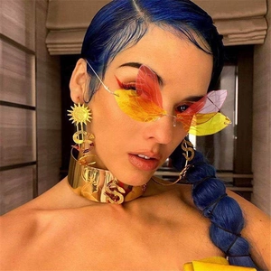 Fashion rimless butterfly wing sunglasses with gold statement earrings on female model