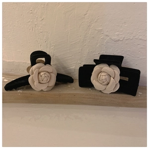 Detail of elegant black velvet hair claws with 3D white camellia flowers in vintage style