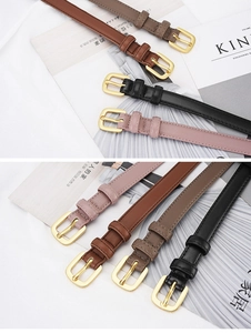 Detailed view of four leather belts in various colors with polished gold buckles