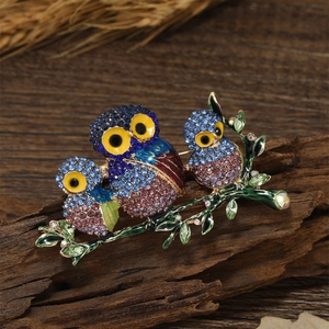 Exquisite owl family crystal brooch on a vintage wood and dried wheat background