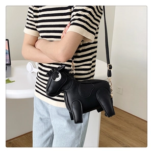 Detail of horse-shaped crossbody bag in textured black leather with gold chain strap