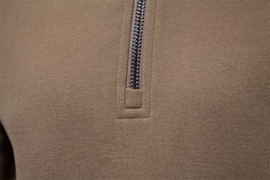 Macro shot of olive green knit fabric with high-quality metal half-zip fastener detail