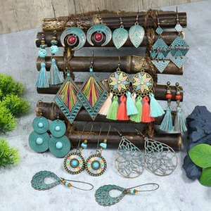 Detail of vintage bohemian earring set with turquoise beads and tassels on a stand