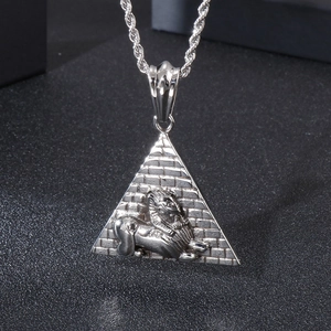 Detailed view of silver pyramid pendant with Sphinx relief and twist chain on dark surface