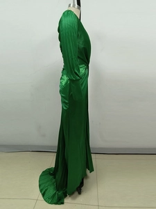 Detail of green satin evening dress featuring pleated waist and elegant long sleeves