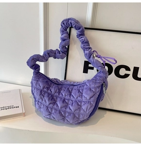 Close-up of purple quilted cloud bag featuring velvet texture and oversized pleated handle