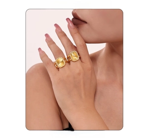 Détail d'une bague rectangulaire dorée avec motif soleil et cristaux de zircone cubique