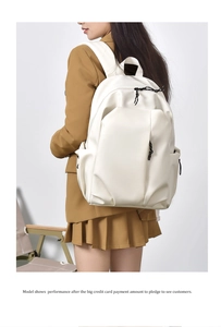 Detail of a minimalist white large capacity backpack featuring matte texture and black pulls
