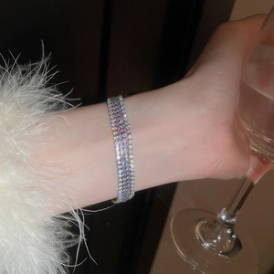 Detailansicht eines luxuriösen mehrlagigen Armbands mit silberner Basis und lila Strasssteinen