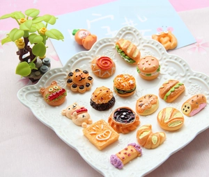 Various miniature resin food models like burgers and donuts arranged on a white tray