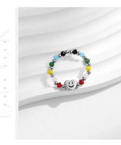 Détail des perles colorées et du pendentif cœur sur une bague élastique en argent S925 pour femme