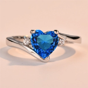Vista macro di pietra blu a cuore e dettagli in zirconia su anello d'argento