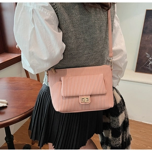 Close-up of pink pleated shoulder bag featuring a gold rotating lock and fine leather texture
