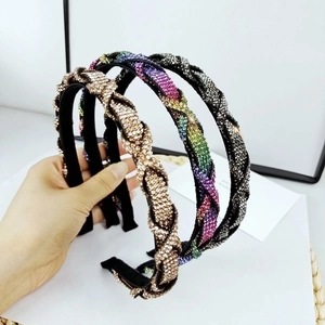 Primer plano de tres diademas de strass trenzado en colores oro, arcoíris y gris oscuro