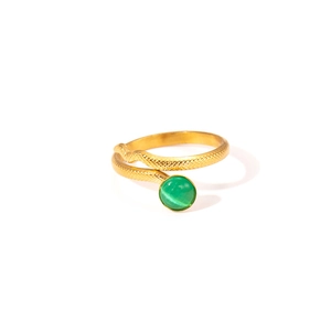 Macro detail of golden snake ring with green cat eye stone and engraved scale texture
