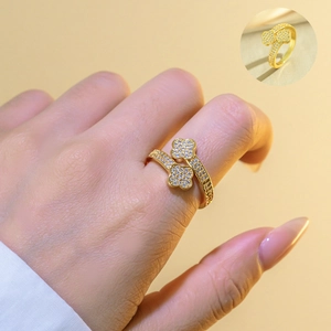 Detail of adjustable gold four-leaf clover ring with white zircon stones on a hand