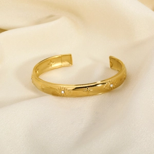 Detailed view of vintage gold hollow heart bracelet with star engraving and zircon