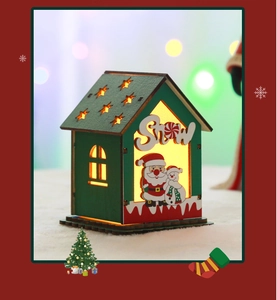 Detail of glowing wooden Christmas house with Snow carving and LED warm lighting