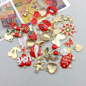 Macro shot of assorted red enamel apple and cherry alloy charms for DIY jewelry making