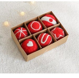Detail view of 6-piece red wool felt Christmas balls with embroidery in a craft gift box