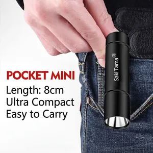 Mini LED flashlight in black aluminum alloy being placed in a pocket for scale