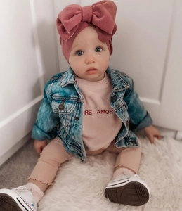 Baby knit turban hat with double bow paired with denim jacket and plush carpet background