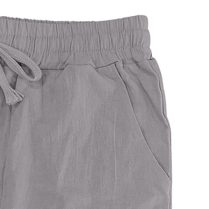 Dettaglio dei pantaloni in lino grigio con vita elastica e coulisse strutturata