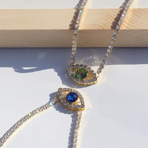 Detail of evil eye necklaces with green and blue cubic zirconia on gold chains