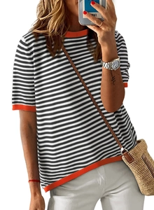Close-up of black and white striped knit sweater with vibrant orange contrast ribbed edges