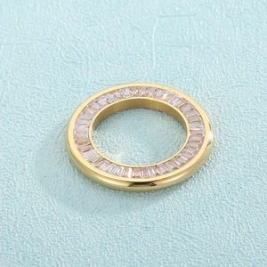 Golden ring featuring channel-set square-cut crystals on light blue background