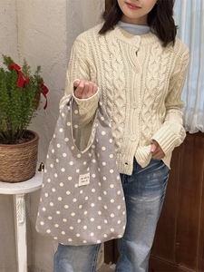 Retro grey canvas tote bag with white polka dots and zakka logo being held by a model