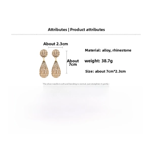Detailed view of large gold drop earrings with full rhinestones and silver needle pins