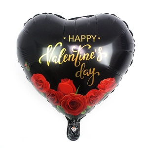 Dettaglio di un palloncino in alluminio nero a forma di cuore con scritte dorate e rose rosse