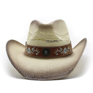 Detail of western straw cowboy hat with embroidered ethnic band and turquoise concho
