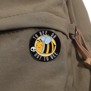 Broche abeille émaillée sur sac à dos avec le texte To Bee Or Not To Bee de forme ronde