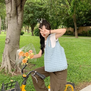 Outdoor shot of light blue bubble textured tote bag with a minimalist quilted floral design