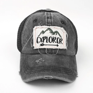 Detailed view of the distressed EXPLORER patch and frayed holes on the washed grey cap