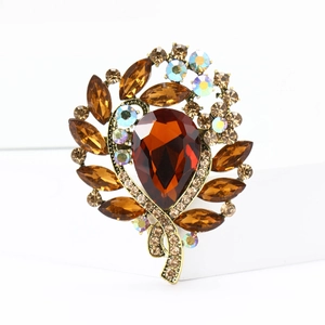 Macro view of vintage bronze alloy brooch featuring amber crystal and AB rhinestones