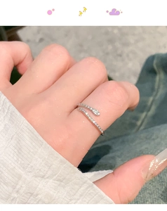 Close-up of silver snake-shaped open ring with cubic zirconia stones on hand