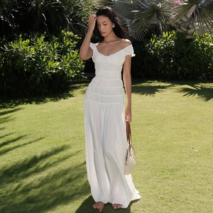 Détail de la robe longue blanche à épaules dénudées avec texture froncée et sac tissé