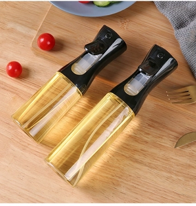 Kitchen oil sprayer bottles on a wooden board with fresh cooking ingredients and vegetables
